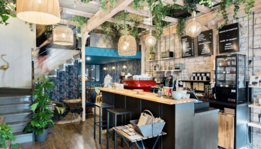 photo intérieur du bar avec vue sur des plantes et le bar ainsi que l'escalier pour accéder aux tables à l'étage