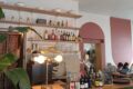 photo de l'intérieur du café, vue sur le bar coloré avec différentes bouteilles et des tables sur le côté