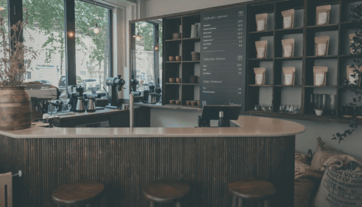 Bar d'un café avec tabourets et le menu sur le mur. La décoration est sombre et a beaucoup de bois