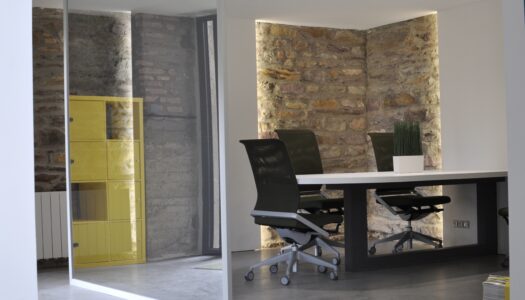 photo de l'intérieur de l'espace de coworking avec bureaux et chaises avec des murs en pierre